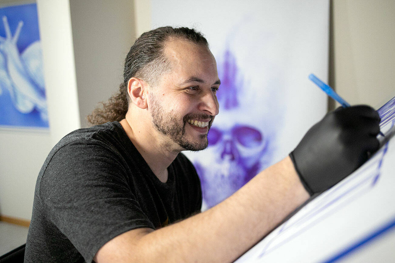 Gabriel Herrera works on a piece of artwork in his studio Tuesday, Feb. 15, 2022, in Lake Stevens, Washington. Herrera said he is in his blue phase as an artist, which is why he uses blue pens to create his art. (Ryan Berry / The Herald)