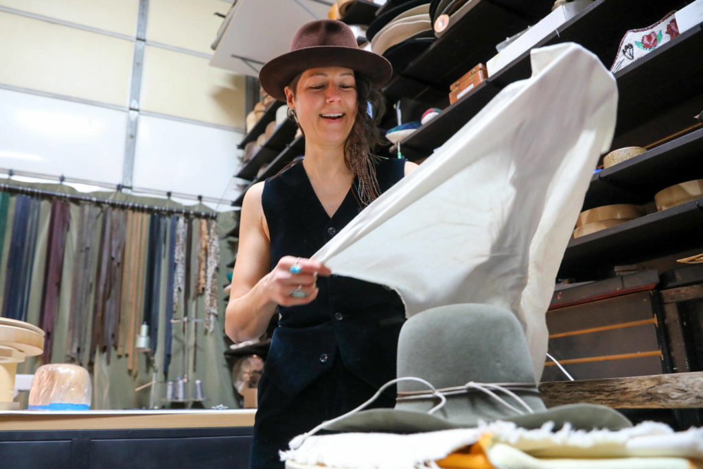 Jac Cash forms and shapes a hat at the FauxyFurr manufacturing shop in Arlington. (Kevin Clark / The Herald )
