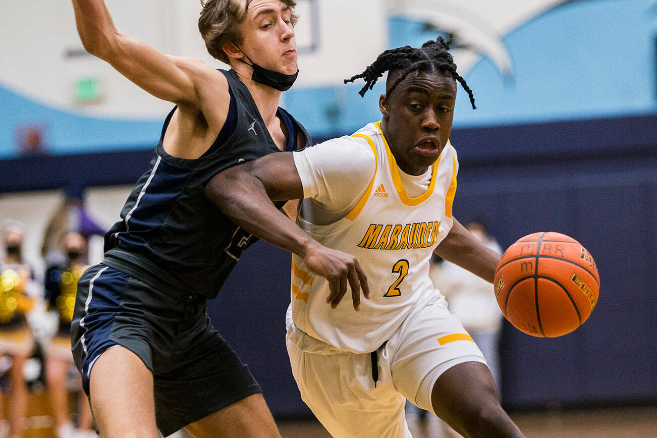 Mariner's Tijan Saine forces his way around Glacier Peak's Jo Lee while driving to the hoop during the game on Tuesday, Jan. 25, 2022 in Everett, Washington. (Olivia Vanni / The Herald)