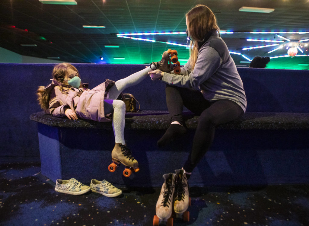 Courtney Simons (right) helps her daughter, Whitaker, 5, put on her skates at Everett Skate Deck. (Olivia Vanni / The Herald)
