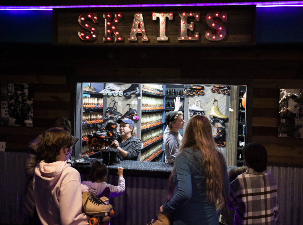 People line up to trade in their shoes for skates on family night at the Everett Skate Deck. (Olivia Vanni / The Herald)
