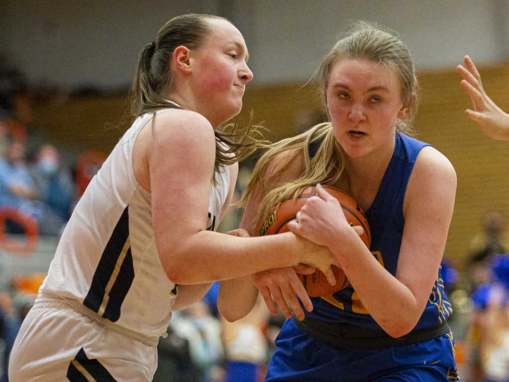 Arlington’s Katie Snow fights for the ball during the game against Kelso on Friday, Feb. 25, 2022 in Everett, Washington. (Olivia Vanni / The Herald)
