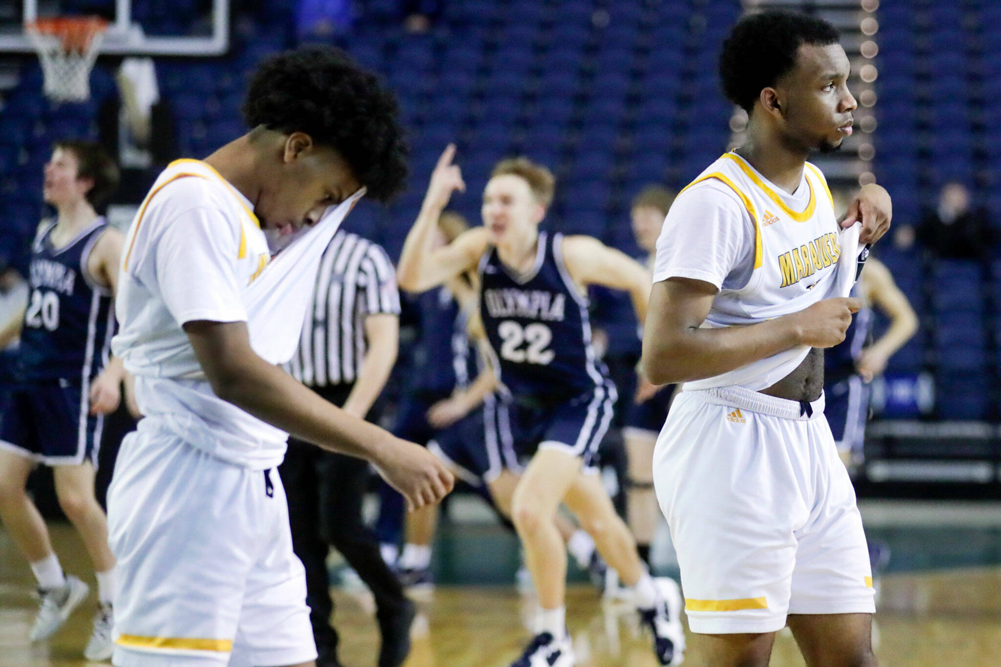 Mariner’s Jailin Johnson (left) and Naser Motley walk to the bench dejected after losing to Olympia on Wednesday afternoon in Tacoma. (Kevin Clark / The Herald)