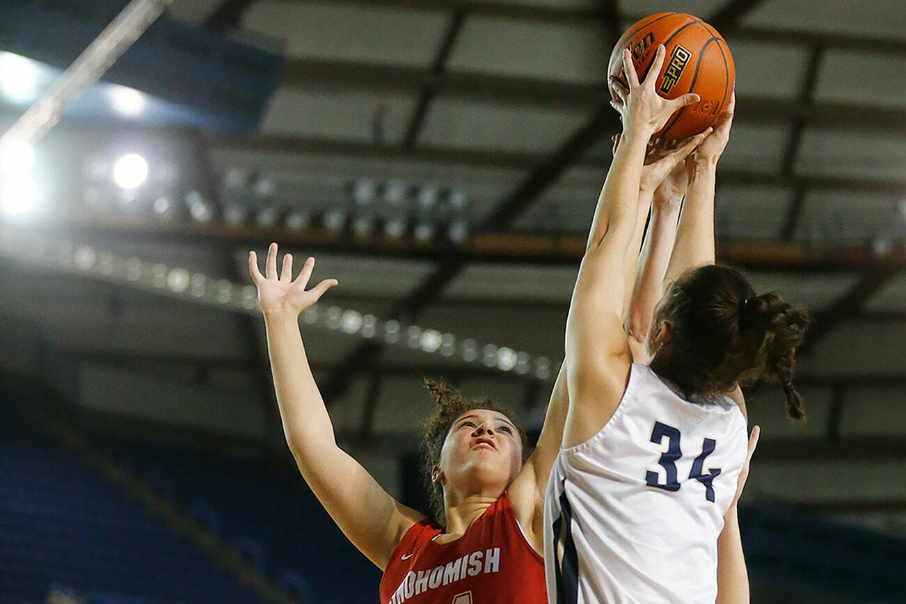 Arlington’s Jenna Villa and Snohomish’s Tyler Gildersleeve-Stiles go up for a rebound Thursday, March 3, 2022, during a 3A matchup at the Tacoma Dome in Tacoma, Washington. (Ryan Berry / The Herald)