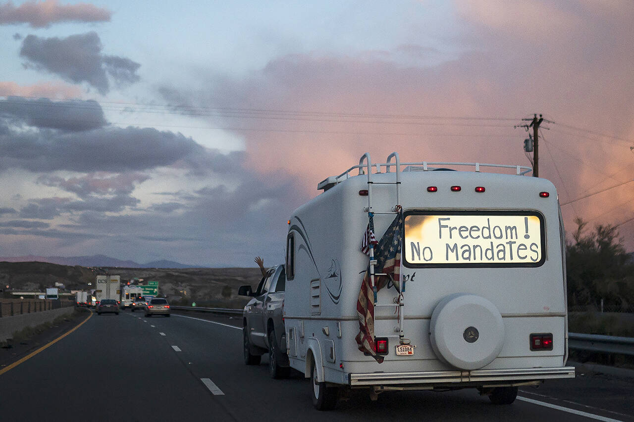 A trailer with the words “Freedom! No Mandate” on its window travels with a caravan heading toward Washington D.C. to protest COVID-19 restrictions on Feb. 23 near Needles, California. On Wednesday in Spokane, a string of cars drove down I-90 as part of a “Freedom Convoy” also headed to Washington D.C. in protest of mask mandates. (AP Photo/Nathan Howard, file)