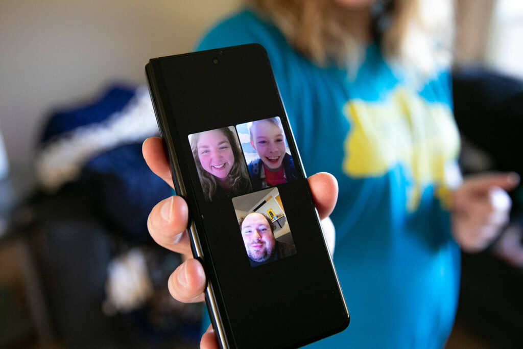 Katie-Jo Page holds up a photo of a recent video chat she, her husband and Mykyta had before the war began, on Sunday in Snohomish. (Ryan Berry / The Herald)
