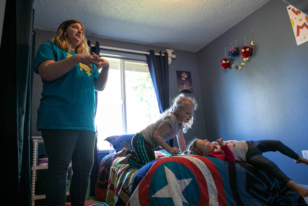 Katie-Jo Page stands in Mykyta’s bedroom as two of her daughters play on his bed Sunday in Snohomish. (Ryan Berry / The Herald)
