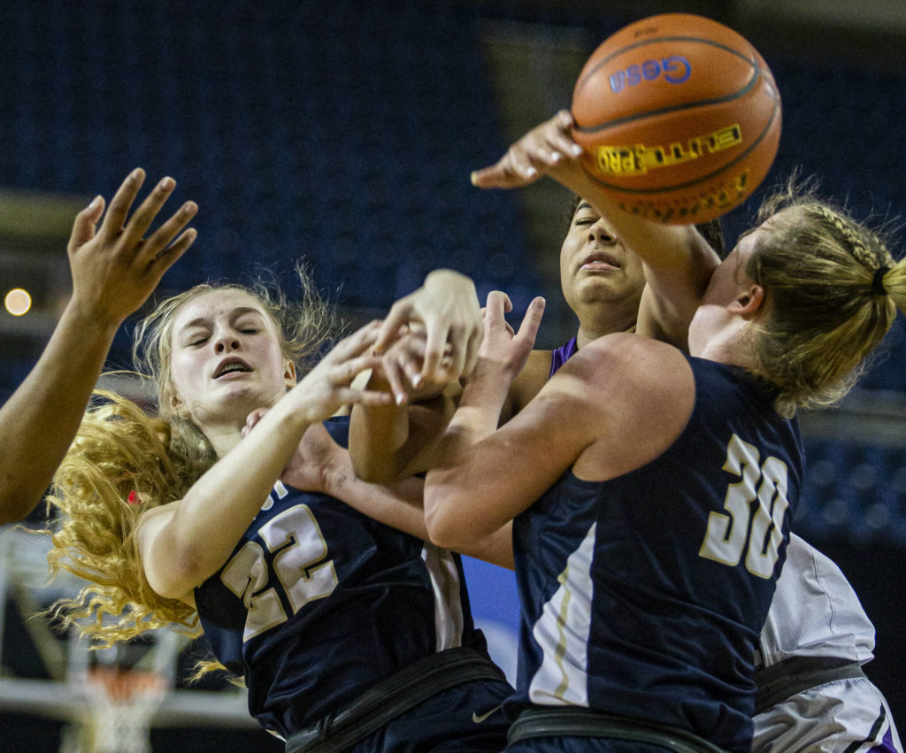 Arlington’s Kierra Reese and Sophie Willis try to rebound the ball during the 3A state semifinal against Garfield at the Tacoma Dome on Friday, March 4, 2022. (Olivia Vanni / The Herald)
