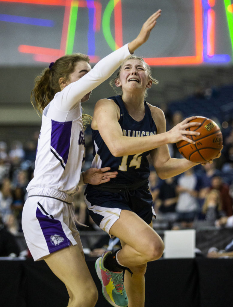 Arlington’s Keira Marsh grimaces as she attempts a layup during the 3A state semifinal against Garfield at the Tacoma Dome on Friday, March 4, 2022. (Olivia Vanni / The Herald)
