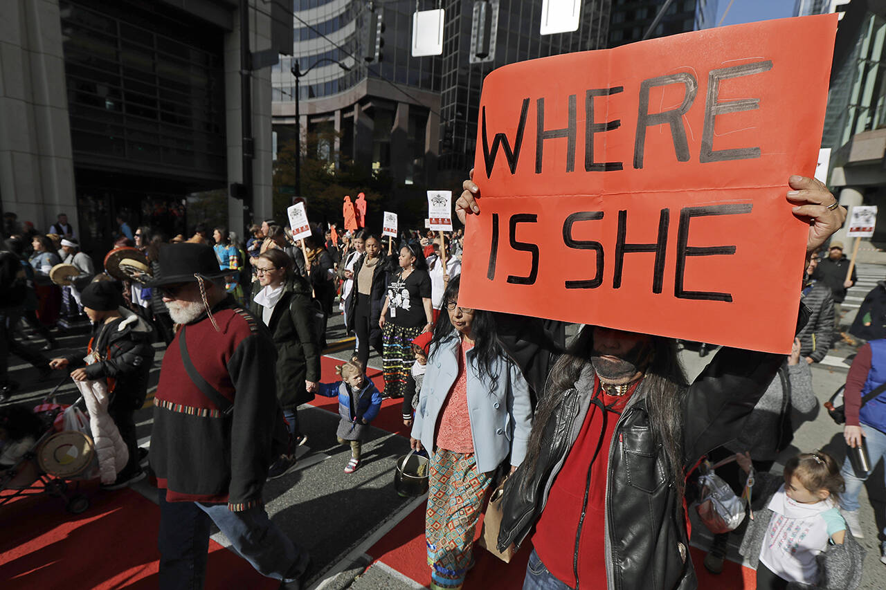 Dennis Willard, of Bellevue, carries a sign that reads “Where Is She” as he marches in support of missing and murdered indigenous women during a rally to mark Indigenous Peoples’ Day in downtown Seattle on Oct. 14, 2019. (AP Photo/Ted S. Warren, file)