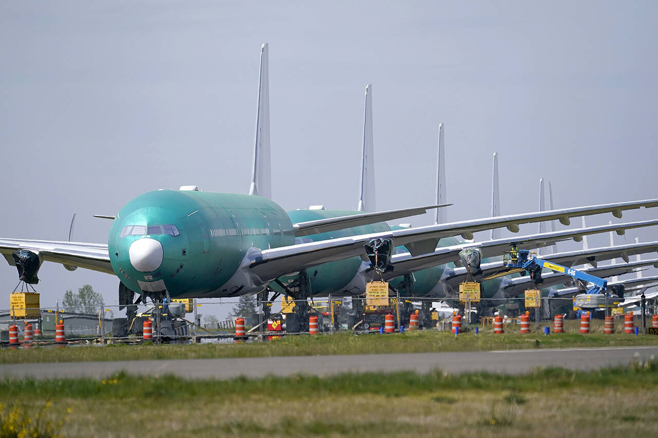 A line of Boeing 777X jets are parked nose to tail on an unused runway at Paine Field, near Boeing’s massive production facility in Everett, on April 23, 2021. (AP Photo/Elaine Thompson, File)