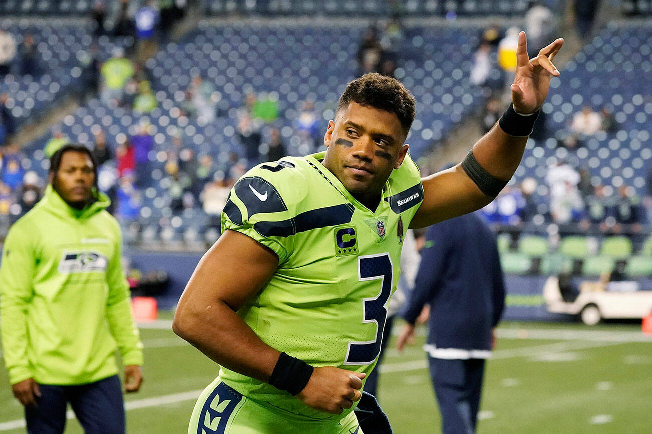 Seattle Seahawks quarterback Russell Wilson waves to fans as he leaves the field after an NFL football game against the Los Angeles Rams, Thursday, Oct. 7, 2021, in Seattle. Wilson suffered a hand injury and the Rams won 26-17. (AP Photo/Elaine Thompson)