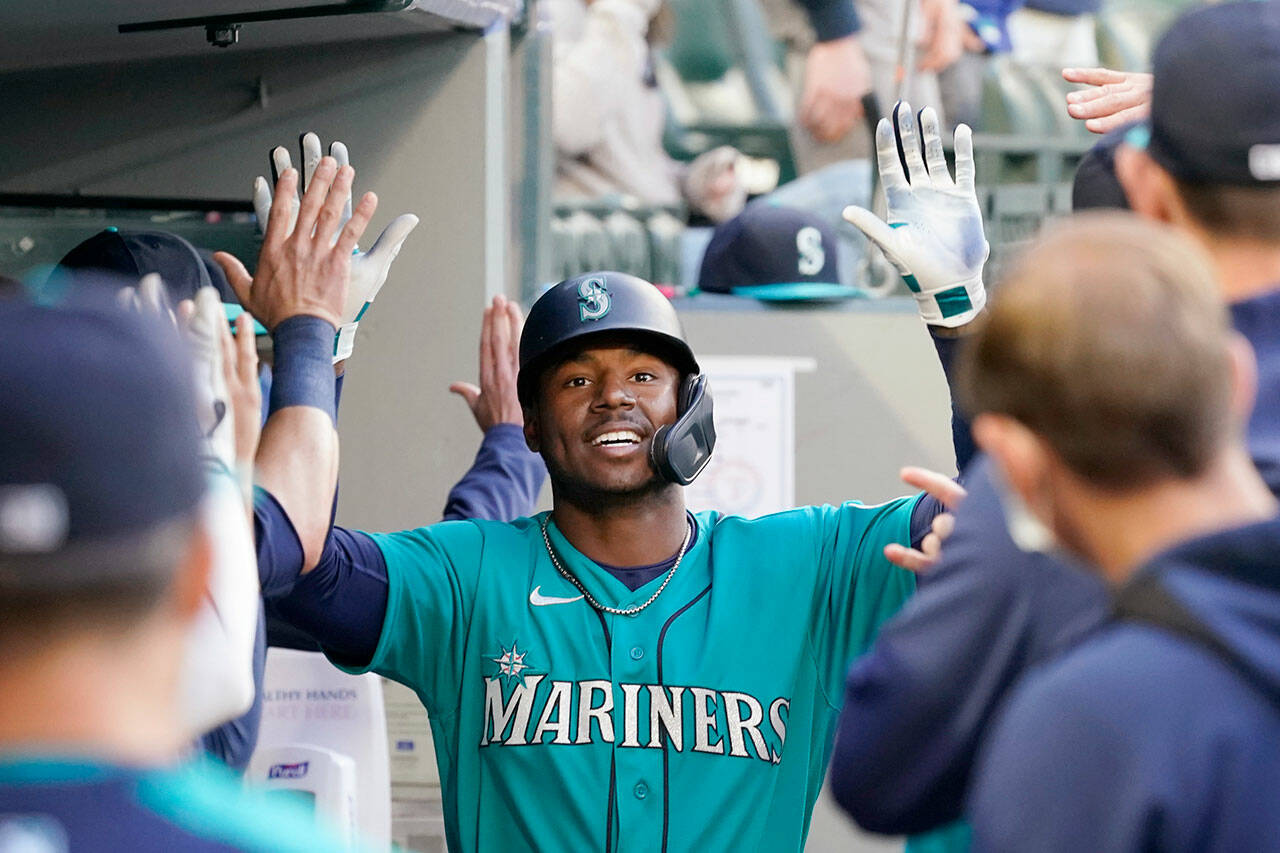 Seattle Mariners’ Kyle Lewis is congratulated after his two-run home run against the Texas Rangers in the third inning of a game May 28, 2021, in Seattle. (AP Photo/Elaine Thompson)