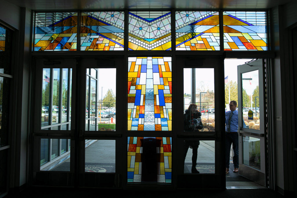 People entering the front doors of Stanwood High School on Wednesday pass beneath one of Jack Archibald’s stained glass windows. (Ryan Berry / The Herald)
