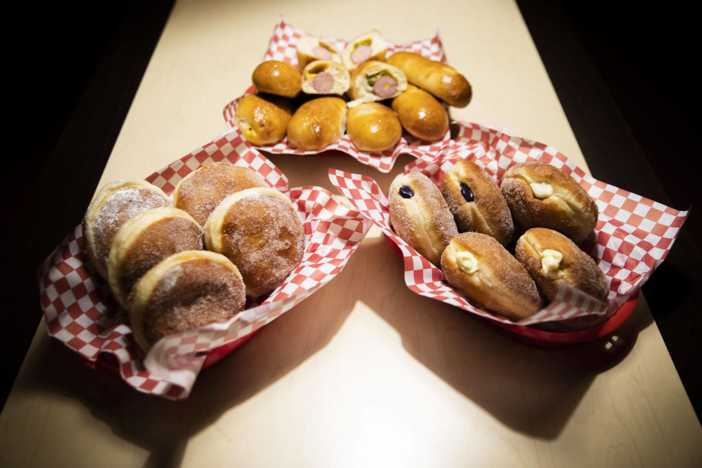 An assortment of sugar-covered-and-filled malasadas and sausage-filled kolaches. (Olivia Vanni / The Herald)

