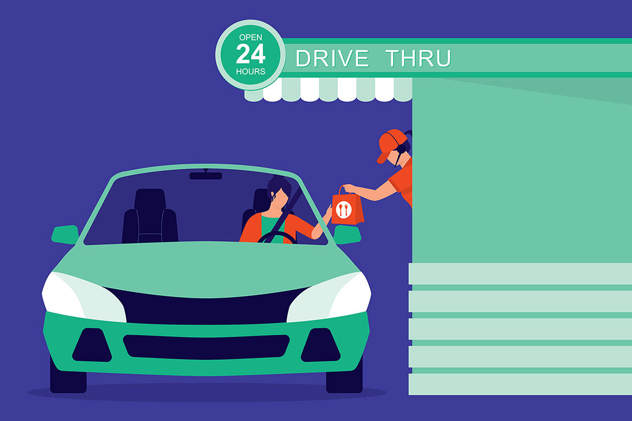 Woman Buying Takeaway Food From Drive-Thru Fast Food Restaurant.