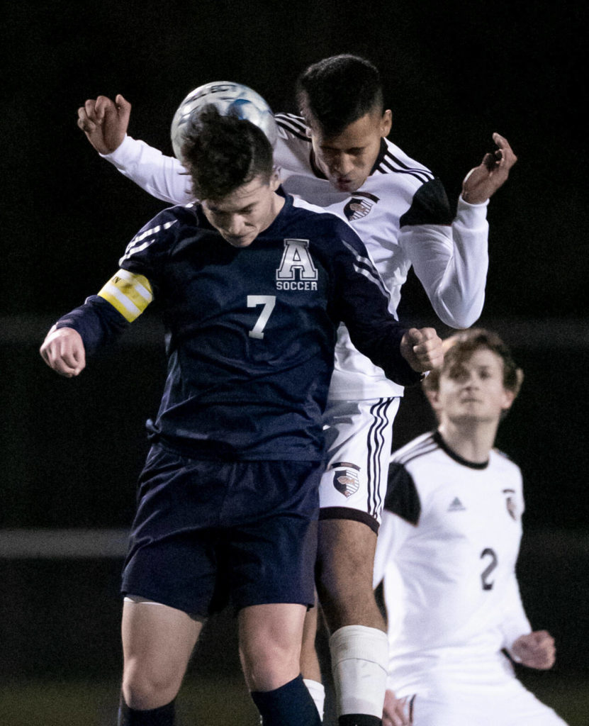 Arlington’s Cameron Mooring, front, and Monroe’s Rafael Garnica jump for a header Friday evening at Arlington High School in Arlington, Washington on March 18, 2022. (Kevin Clark / The Herald)
