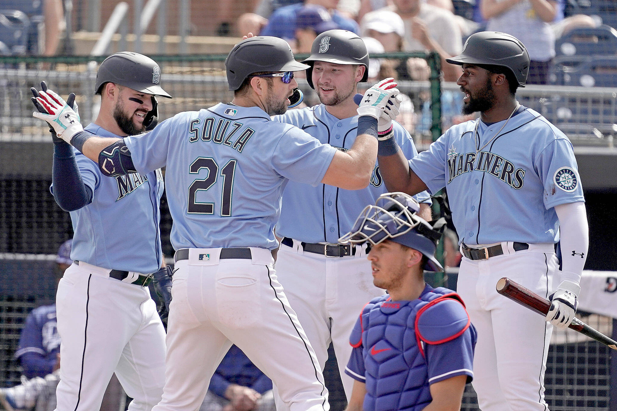 The Mariners’ Steven Souza Jr. (21) celebrates with teammates after hitting a grand slam during the first inning of a spring training game against the Dodgers on Saturday in Peoria, Ariz. (AP Photo/Charlie Riedel)