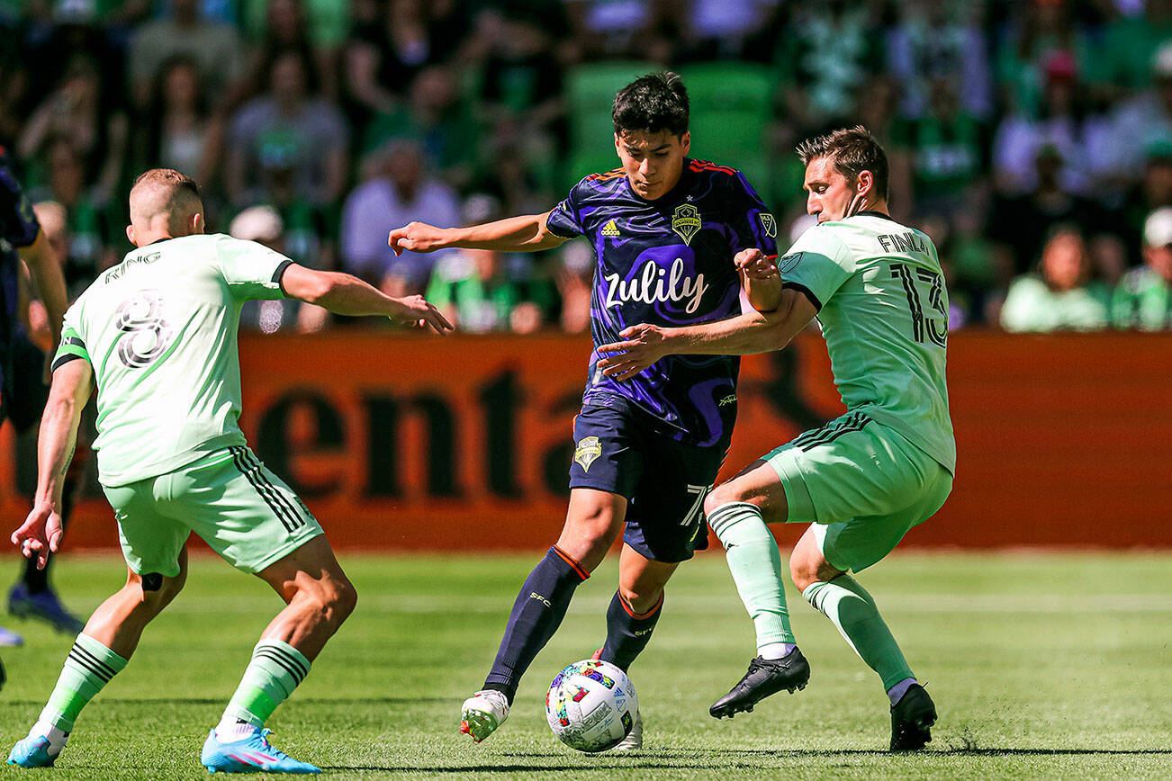 Seattle Sounders FC midfielder Obed Vargas (73) pushes past Austin FC midfielders Alex Ring (8) and Ethan Finlay (13) during an MLS soccer match at Q2 Stadium in Austin, Texas, Sunday, March 20, 2022. (Aaron E. Martinez/Austin American-Statesman via AP)