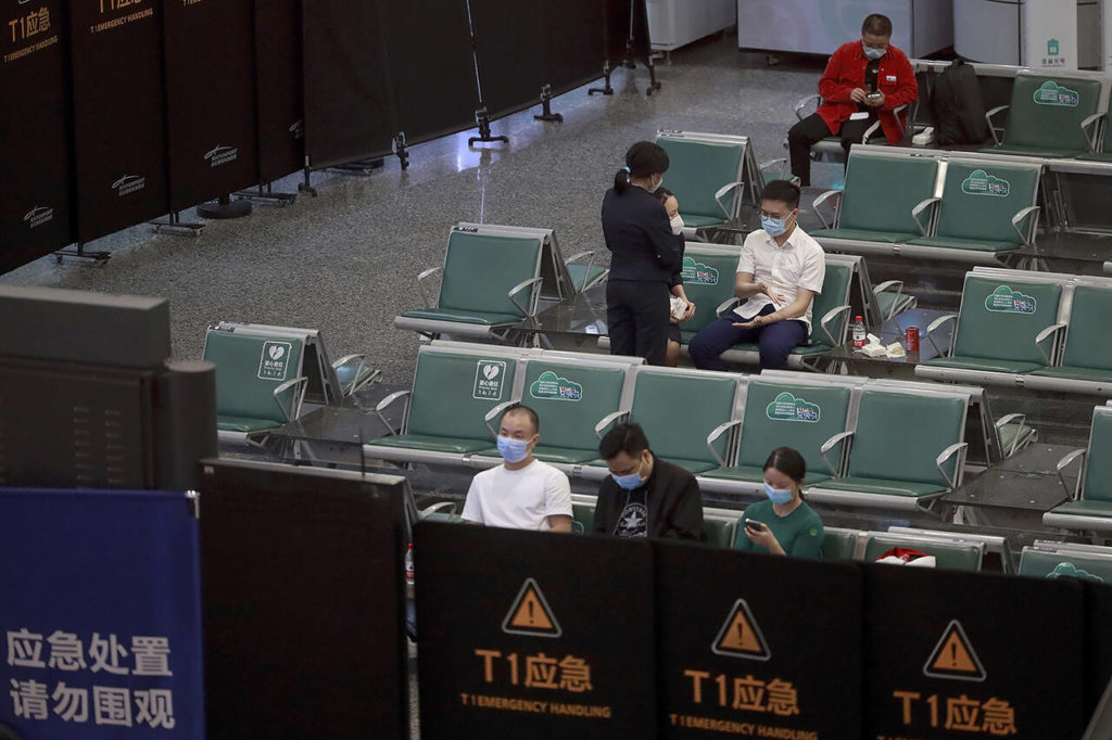 People sit in a temporarily cordoned off area for the relatives of the victims aboard China Eastern’s flight MU5735, in Guangzhou Baiyun International Airport in Guangzhou, capital of south China’s Guangdong Province on Monday. A China Eastern Boeing 737-800 with 132 people on board crashed in the southern province of Guangxi on Monday, officials said. (Chinatopix via AP)
