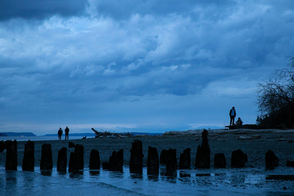 People enjoy the fading light of dusk on a mild evening at Picnic Point Park on March 18 in Edmonds. (Ryan Berry / The Herald)
