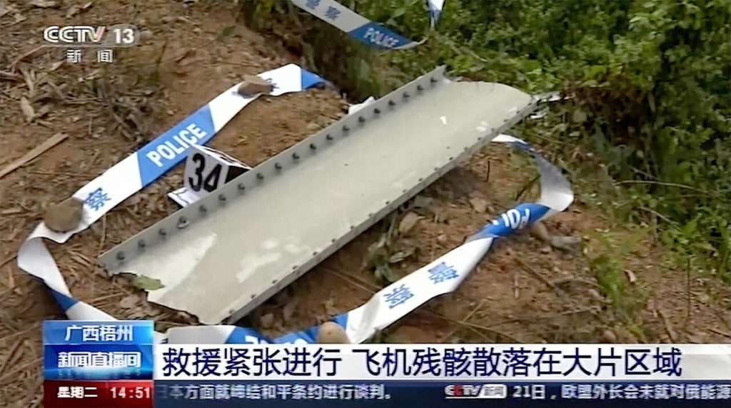 Debris is surrounded by police tape at the site of a plane crash in Tengxian County in southern China’s Guangxi Zhuang Autonomous Region on Tuesday. (CCTV via AP Video)
