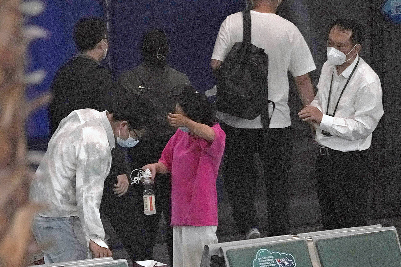 A woman reacts as she prepares to leave an area for relatives of the passengers aboard China Eastern's flight MU5735 at the Guangzhou Baiyun International Airport, Tuesday, March 22, 2022, in Guangzhou. No survivors have been found as rescuers on Tuesday searched the scattered wreckage of a China Eastern plane carrying 132 people that crashed a day earlier on a wooded mountainside in China's worst air disaster in more than a decade. (AP Photo/Ng Han Guan)