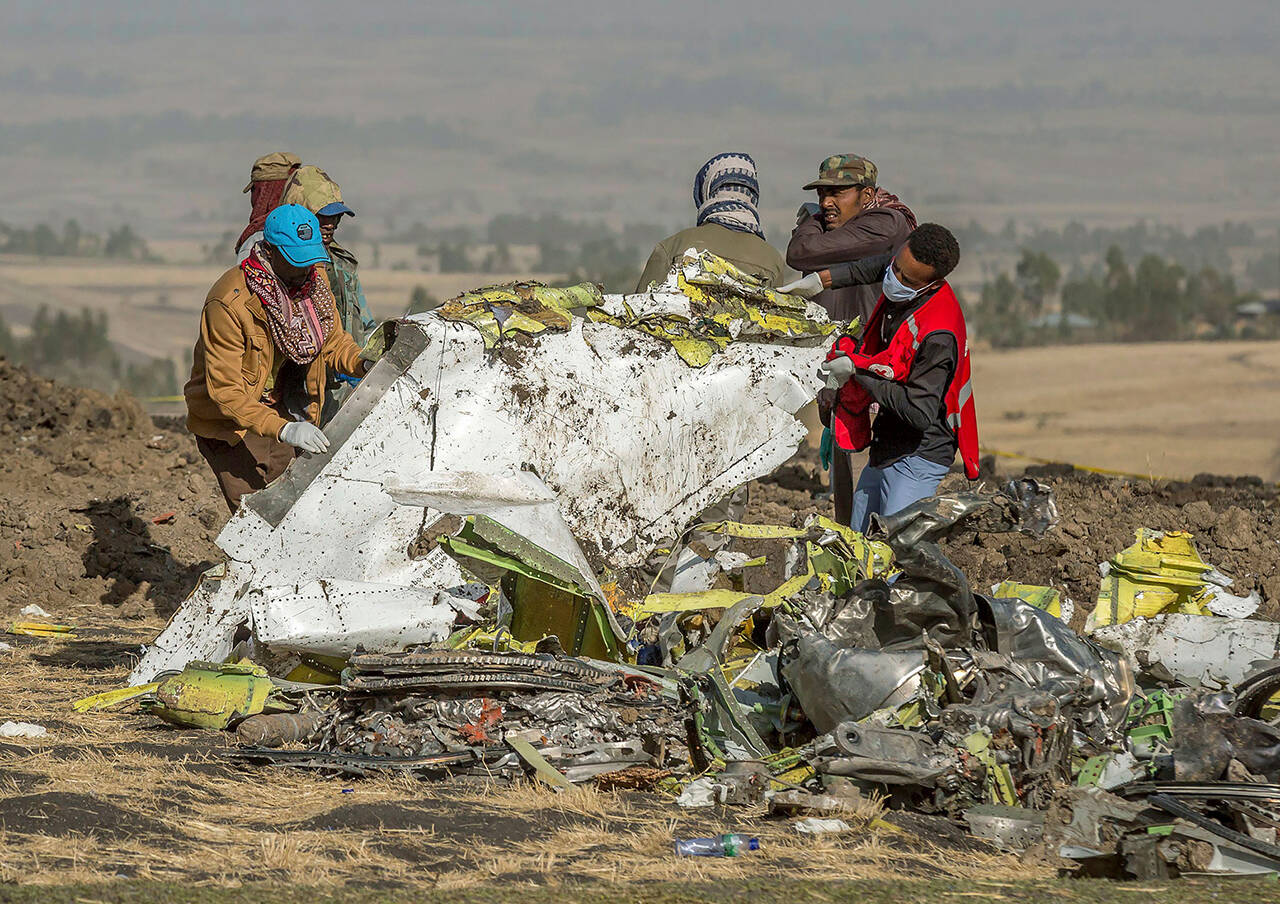 In this file photo dated Monday, March 11, 2019, rescuers work at the scene of an Ethiopian Airlines Boeing 737 Max plane crash south of Addis Ababa, Ethiopia. (AP Photo/Mulugeta Ayene, FILE)