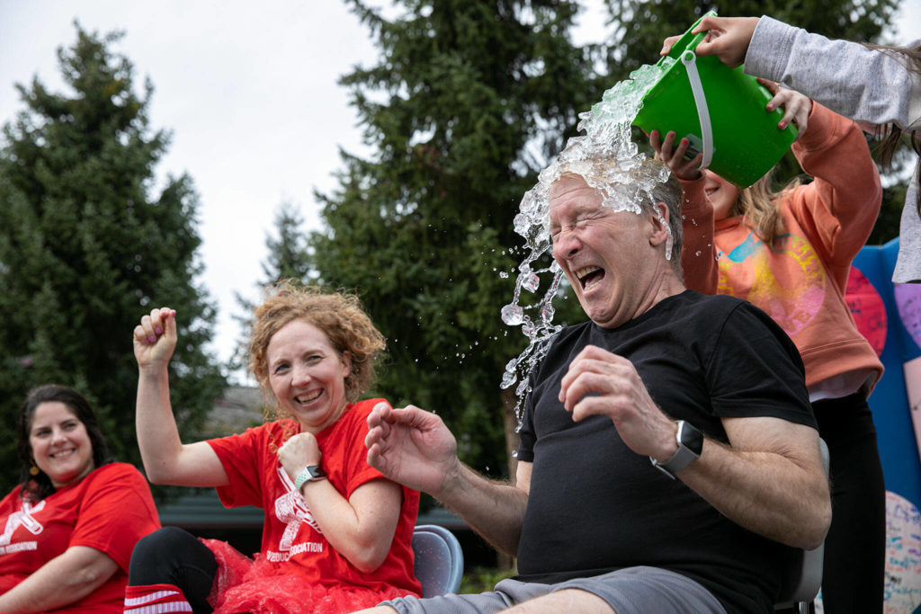Cedar Wood principal Bruce Rhodes reacts as he gets drenched. (Ryan Berry / The Herald)
