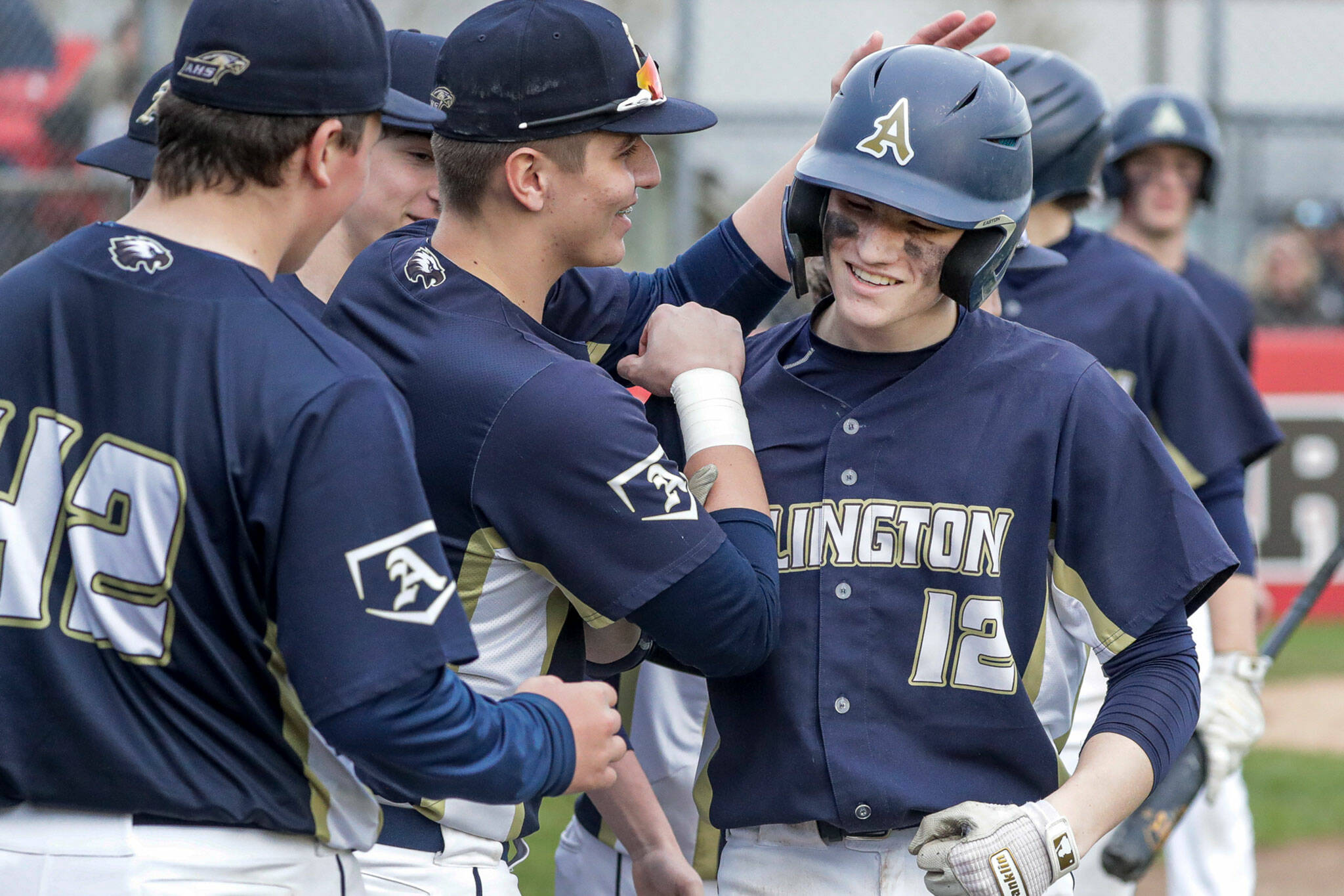 Arlington’s Cooper McBride (12) is congratulated for his two-run home run in the seventh inning against Snohomish Friday afternoon at Snohomish High School. The Eagles won 4-2. (Kevin Clark / The Herald)