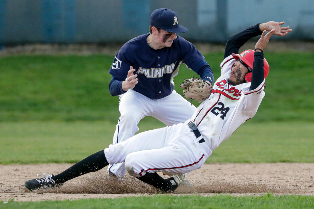 Snohomish’s Nickolas Sakamoto is tagged out shy of second base by Arlington’s Aiden Green Friday afternoon at Snohomish High School. The Eagles won 4-2. (Kevin Clark / The Herald)
