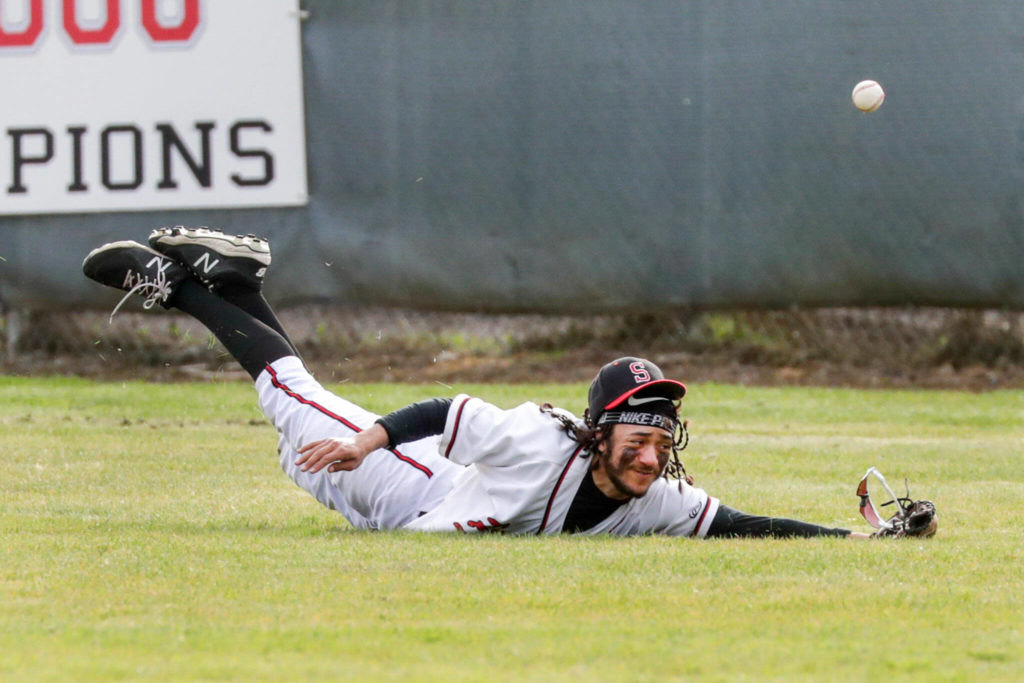 Snohomish’s Nickolas Sakamoto dives for the ball in center field against Arlington Friday afternoon at Snohomish High School. The Eagles won 4-2. (Kevin Clark / The Herald)
