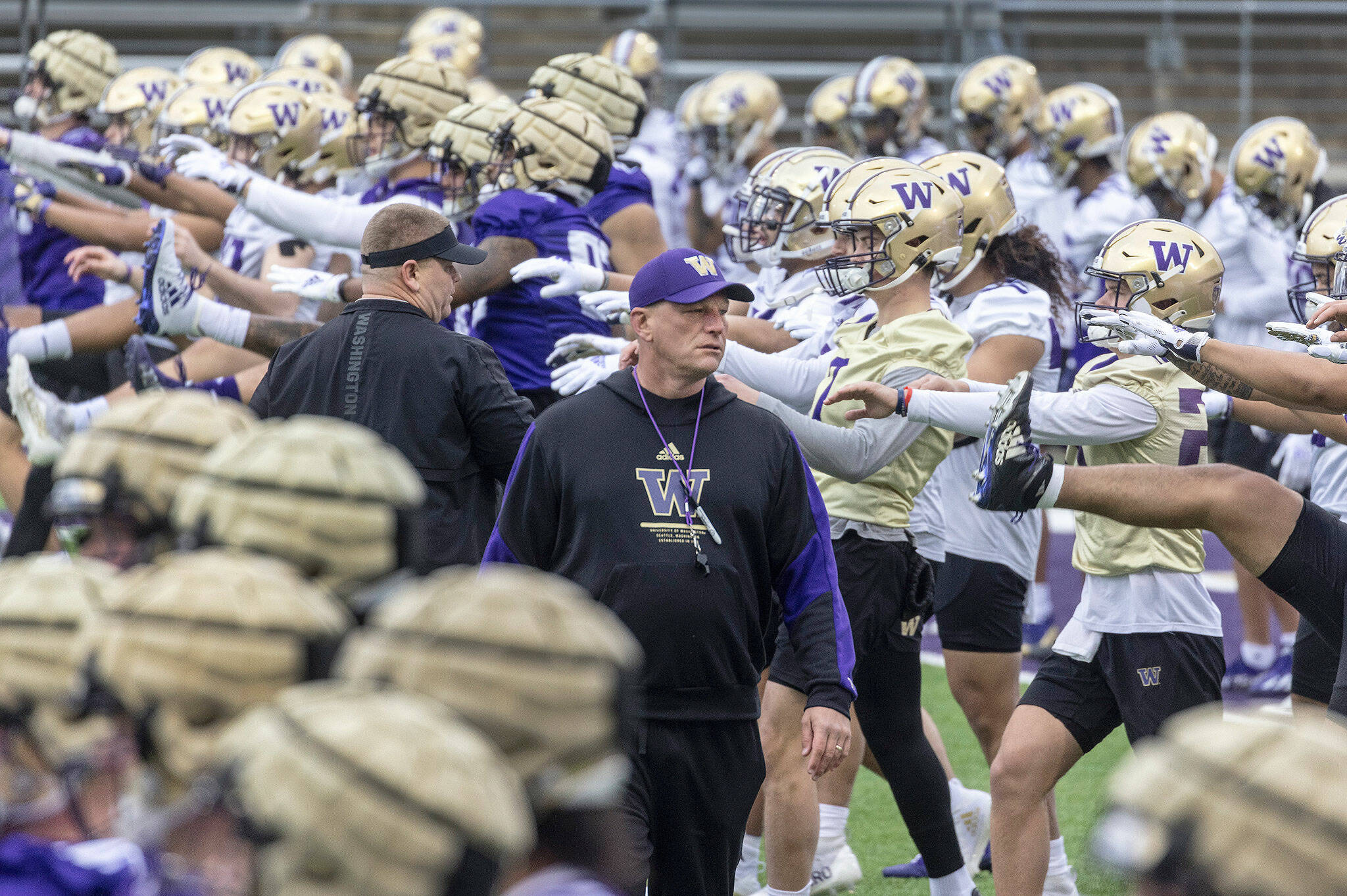 Washington coach Kalen Deboer walks among players and staff as they perform early morning warm-ups during spring practice Wednesday in Seattle. (Steve Ringman/The Seattle Times via AP)