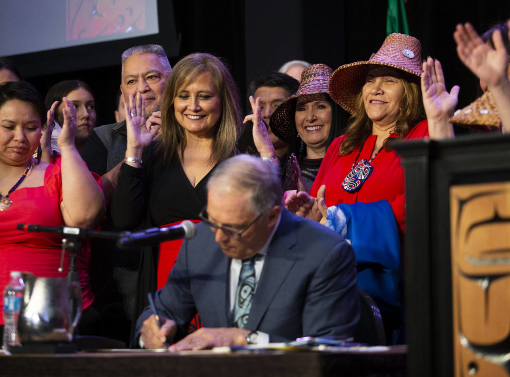 On the Tulalip Reservation, Washington Gov. Jay Inslee (center) signs a bill Thursday that creates a first-in-the-nation statewide alert system for missing Indigenous people. (Olivia Vanni / The Herald)
