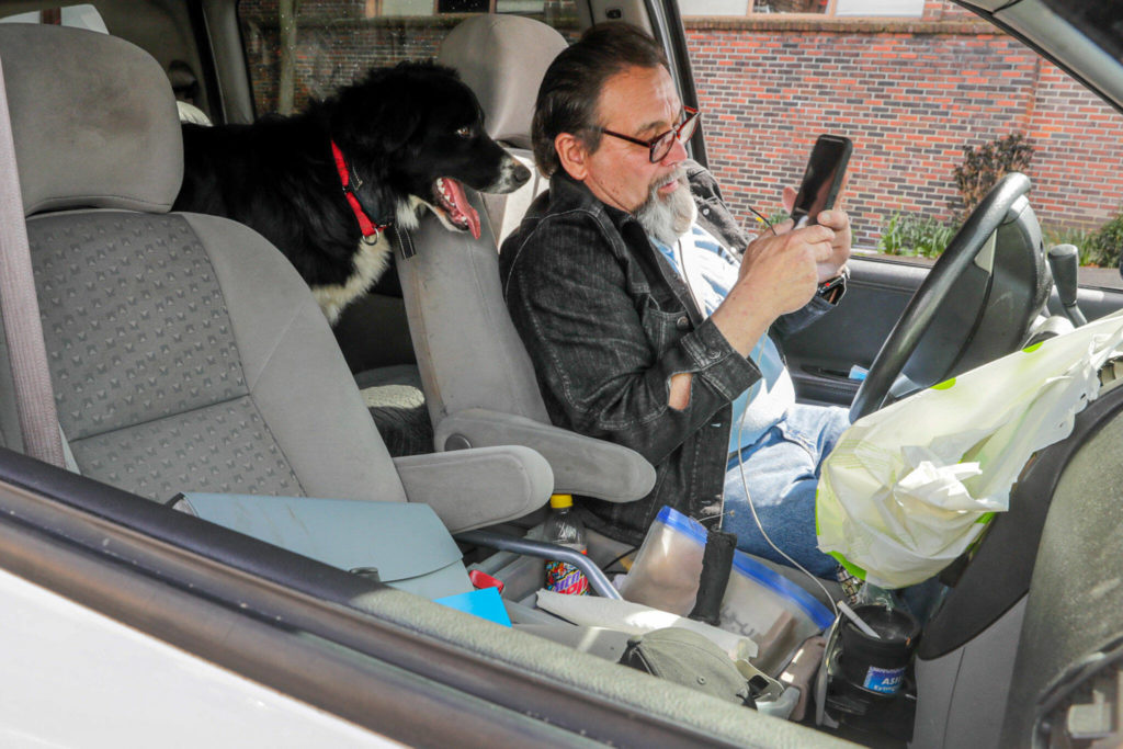 Mike Kersey fields a call for transport to a detox center while in Everett. (Kevin Clark / The Herald) 
