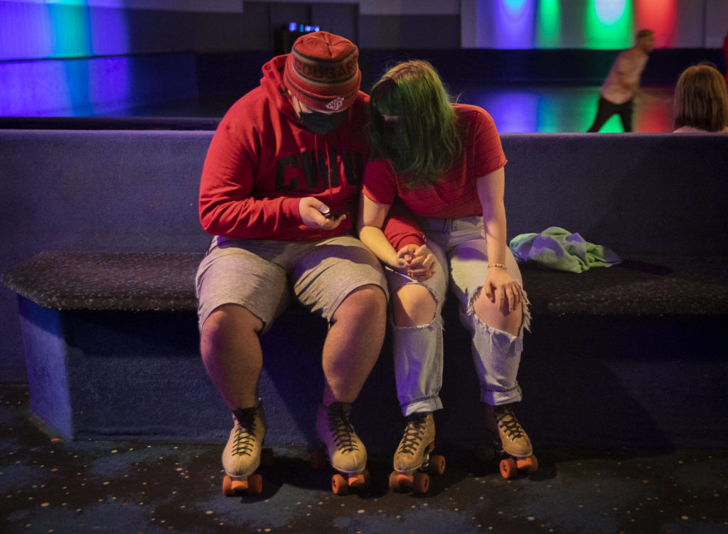 Layney Dodd and Michael Noonan hold hands before heading out onto the floor on Sunday at the Everett Skate Deck. (Olivia Vanni / The Herald)
