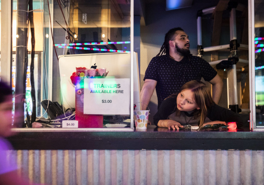 CJ Lewis and Alex Queen wait for the recipient of a secret admirer rose to come to the booth to claim it on Sunday at the Everett Skate Deck. (Olivia Vanni / The Herald)
