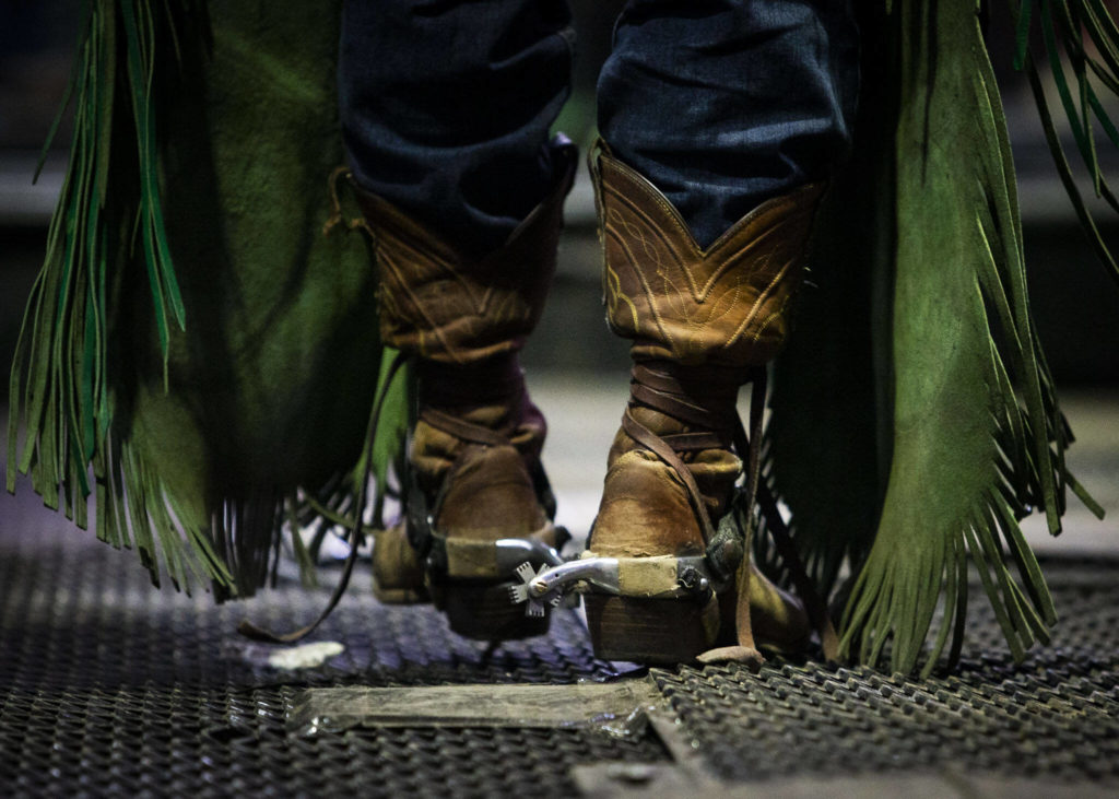 A bull rider walks into the chutes during the PBR Everett Invitational at Angel of the Winds Arena on Wednesday, April 6, 2022 in Everett, Washington. (Olivia Vanni / The Herald)
