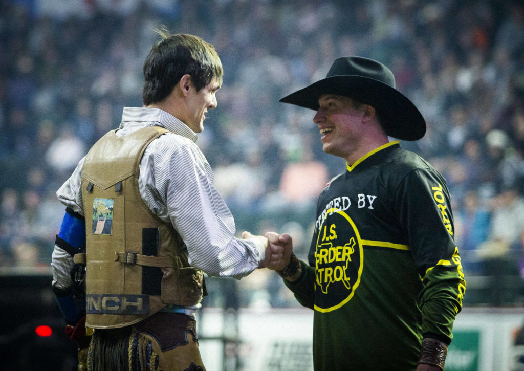 Chase Dougherty gets a fist bump after a qualifying ride during the PBR Everett Invitational at Angel of the Winds Arena on Wednesday, April 6, 2022 in Everett, Washington. (Olivia Vanni / The Herald)
