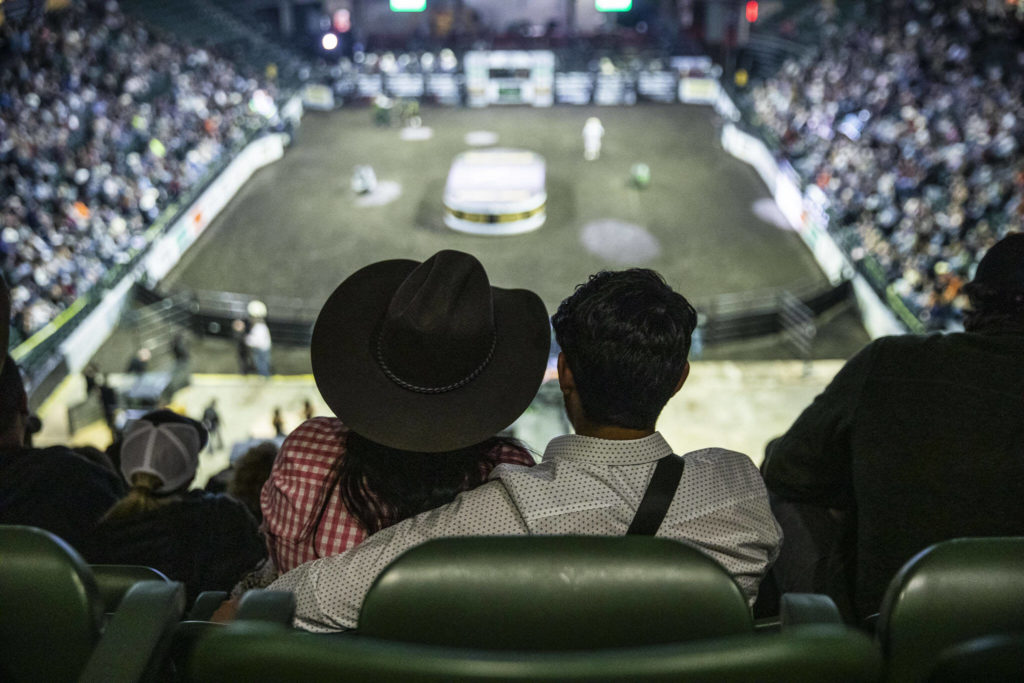 A couple watches the PBR Everett Invitational at Angel of the Winds Arena on Wednesday, April 6, 2022 in Everett, Washington. (Olivia Vanni / The Herald)
