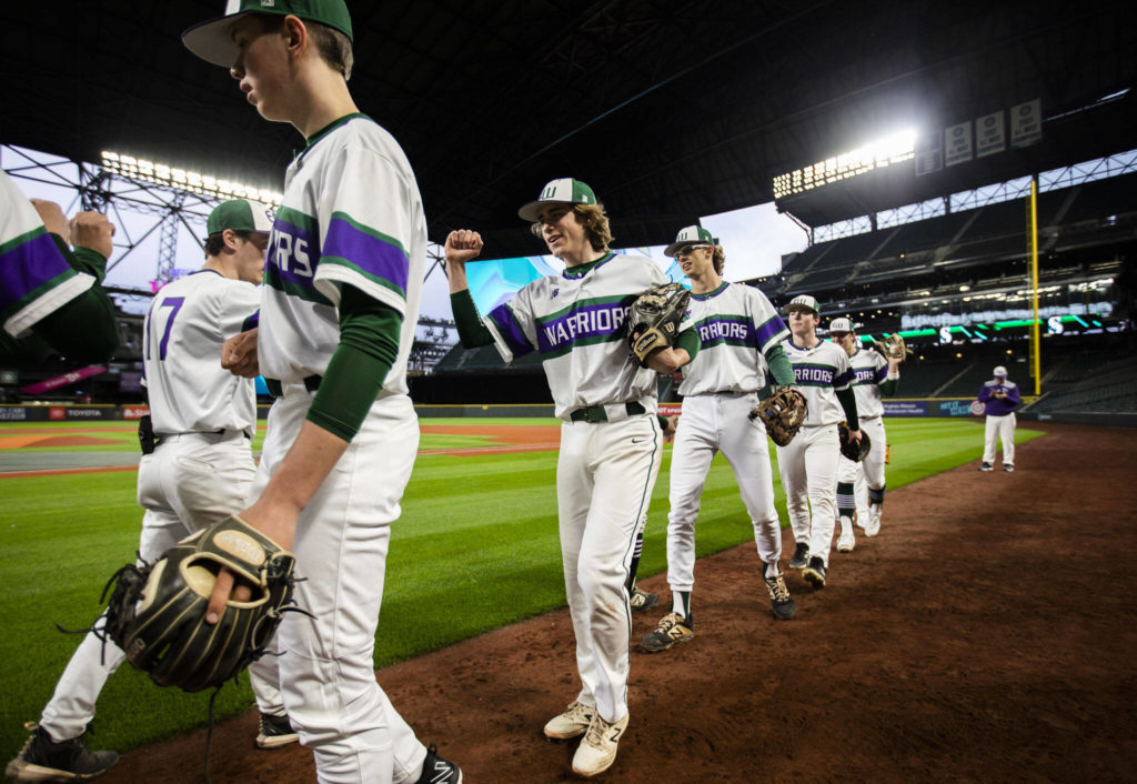 Edmonds-Woodway’s Grant Oliver smiles while fist-bumping his teammates before the start of the game. (Olivia Vanni / The Herald)
