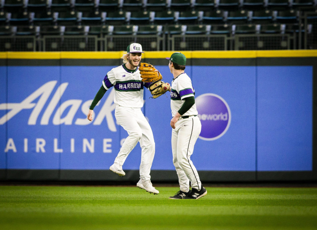Edmonds-Woodway’s Jonah Brower smiles and high-fives teammate Jens Simonsen after making a catch in the outfield. (Olivia Vanni / The Herald)
