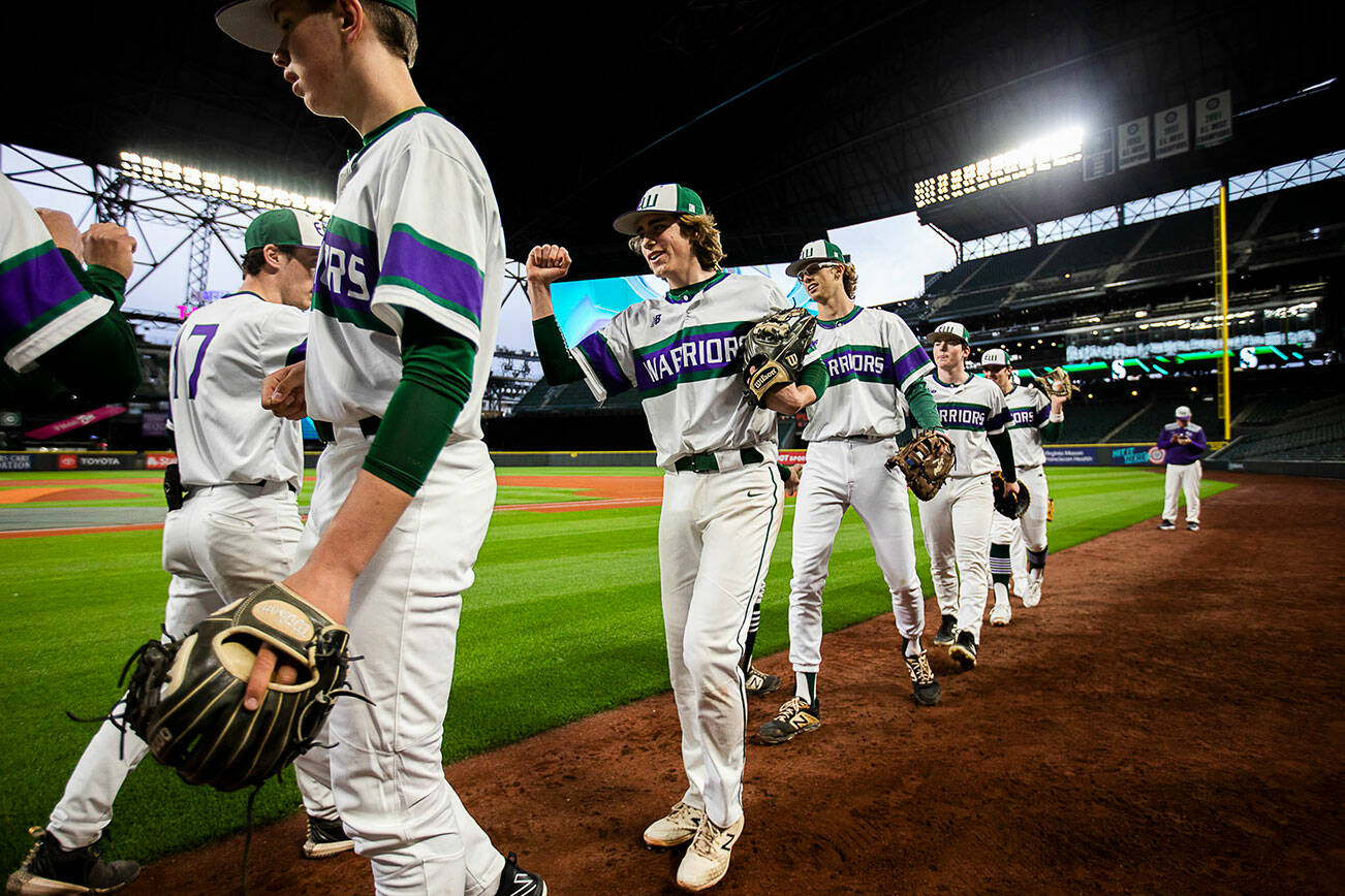 Edmonds-Woodway’s Grant Oliver smiles while fist-bumping his teammates before the start of their game against Kentwood at T-Mobile Park on Friday, April 8, 2022 in Seattle, Washington. (Olivia Vanni / The Herald)