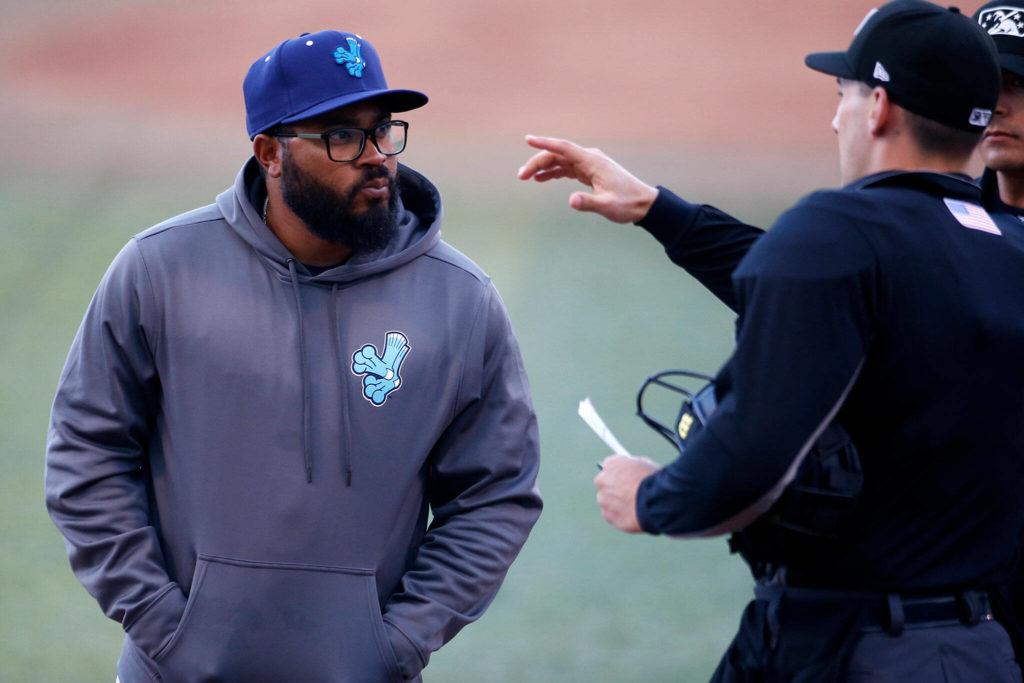 AquaSox manager Eric Farris talks with the umpires before a game against Eugene Friday, April 8, 2022, at Funko Field in Everett, Washington. (Ryan Berry / The Herald)
