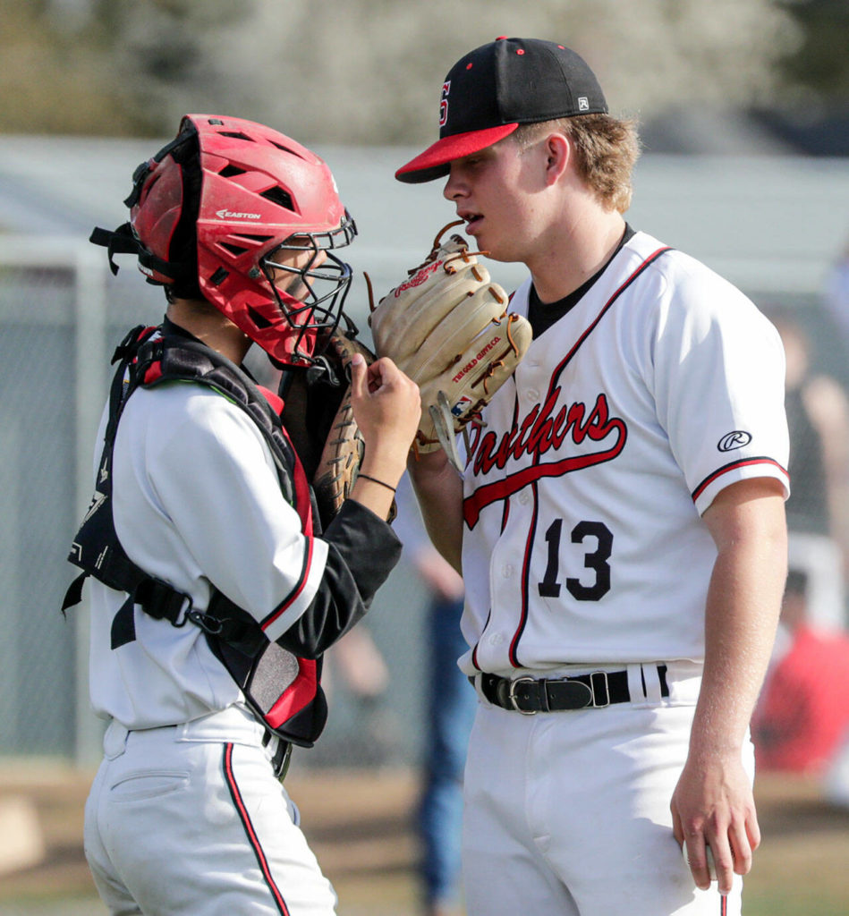 Josh Macagba (left) talks with Kale Hammer on the mound against Marysville-Getchell at Snohomish High School on April 7. (Kevin Clark / The Herald)
