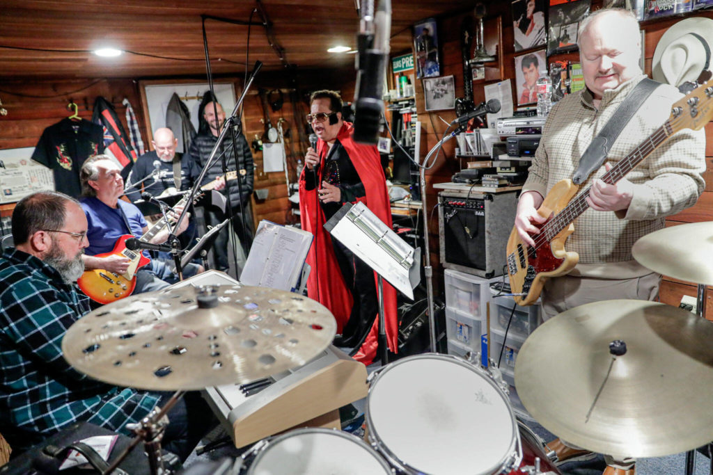 Gus Mansour (center) rehearses with Rob Schwertley (standing left) with Kentucky Rain Band members Steven Preszler, Jeff Olson, Troy Briggs and Dallas Cooper for Friday’s “Elvis Challenge” in Everett. (Kevin Clark / The Herald)
