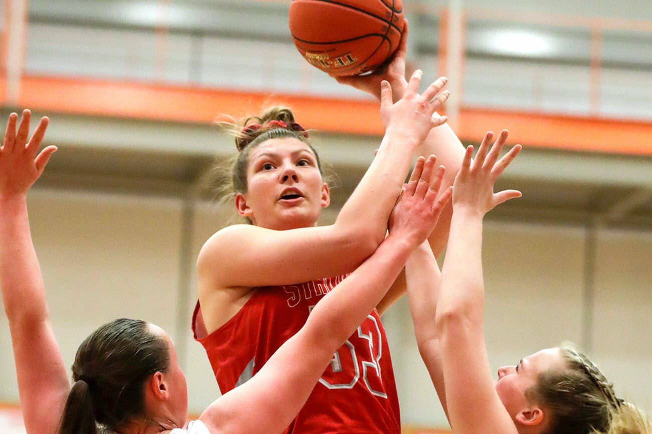 Stanwood’s Vivienne Berrett attempts over Arlington defense Saturday evening at during the 3A District 1 Title game at Everett Community College in Everett, Washington on February 19, 2022. (Kevin Clark / The Herald )