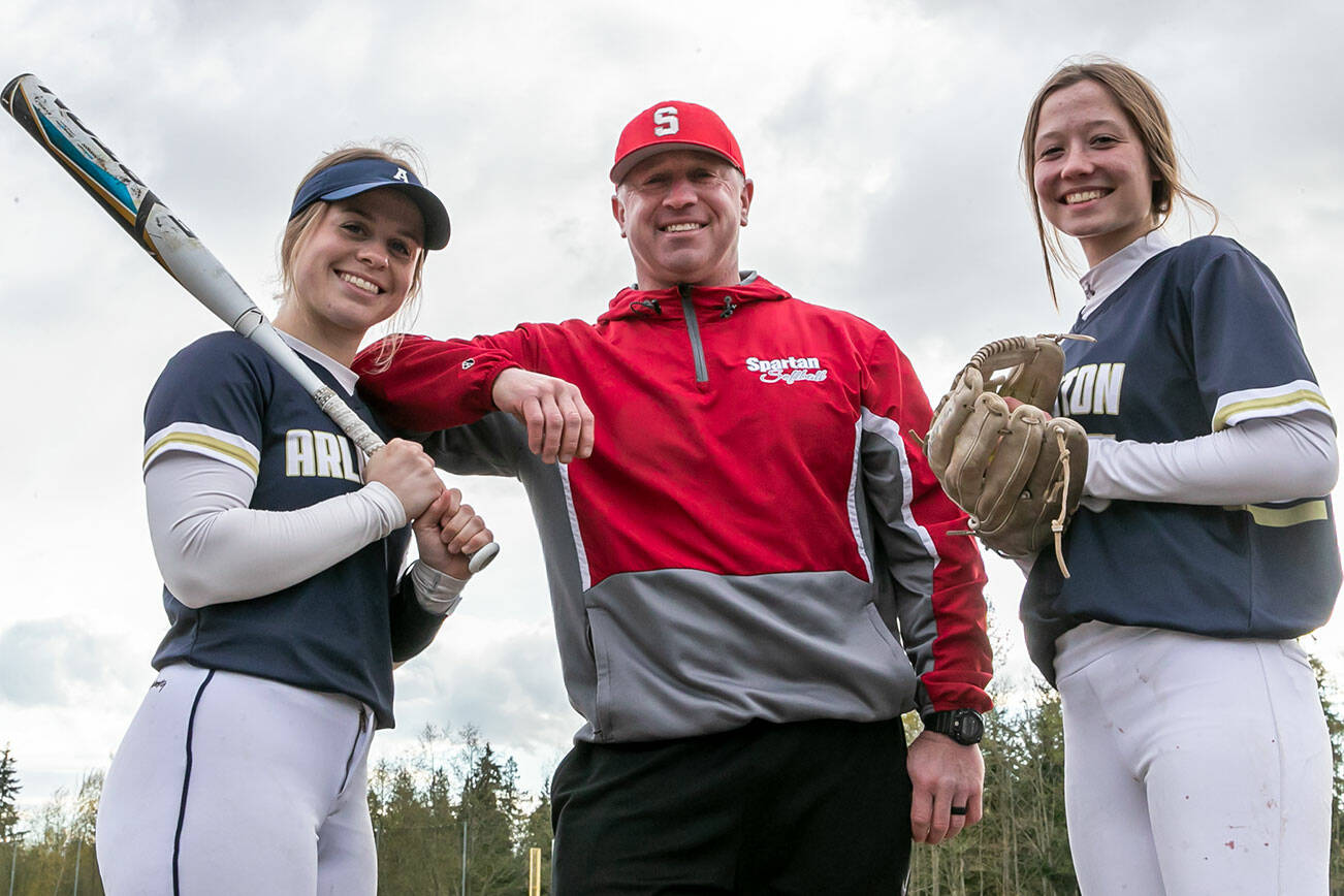 Arlington’s Riley Ryan, left, and Reagan Ryan with their father Patrick Ryan, Stanwood’s head coach Monday afternoon at Arlington High School in Arlington, Washington on April 11, 2022. (Kevin Clark / The Herald)