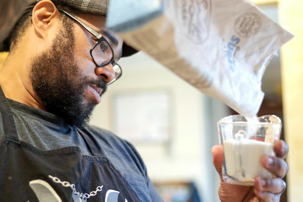Charles Gill measures sugar for a cannabis-infused sweet potato cheesecake. (Kevin Clark / The Herald)
