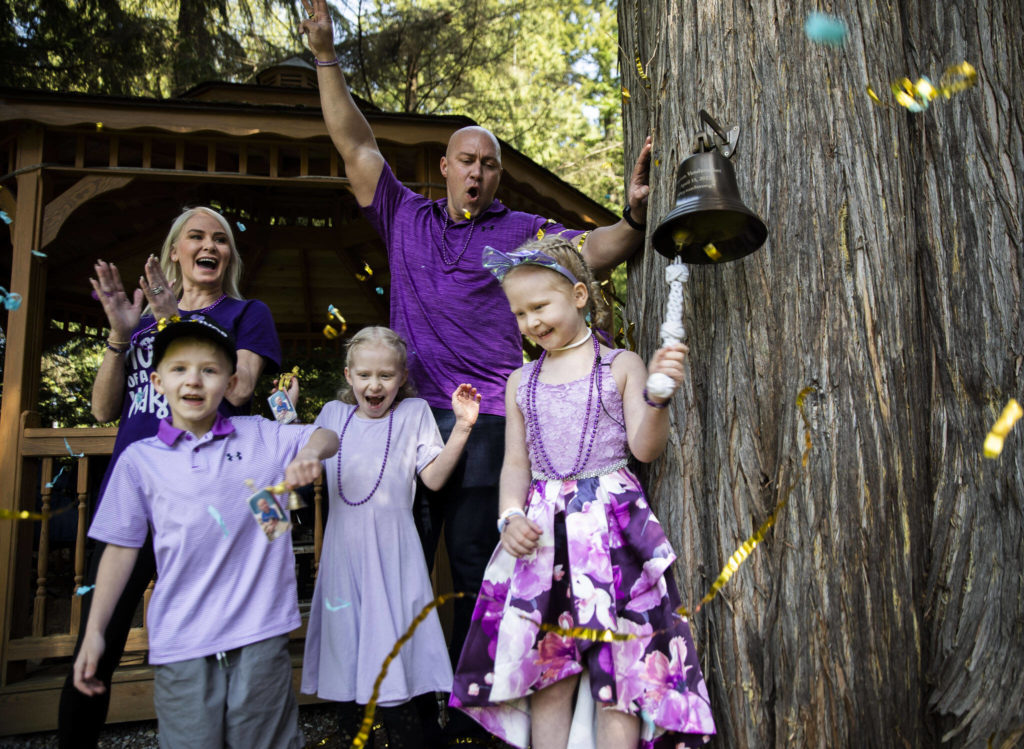 Peyton Vandanacker, 7, rings her bell surrounded by her family in celebration of the end of her chemotherapy treatment for an aggressive type of leukemia on Saturday, April 23, 2022 in Bothell, Washington. (Olivia Vanni / The Herald)
